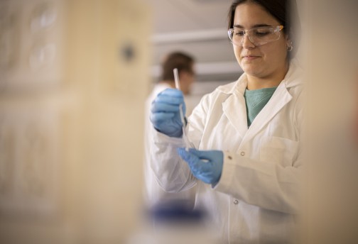 A woman wearing a lab coat conducting research 