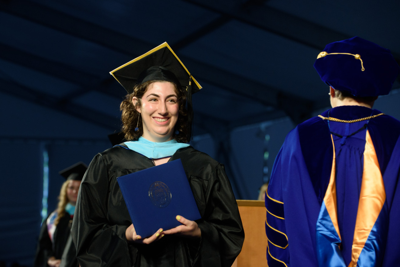 student receives her diploma on stage
