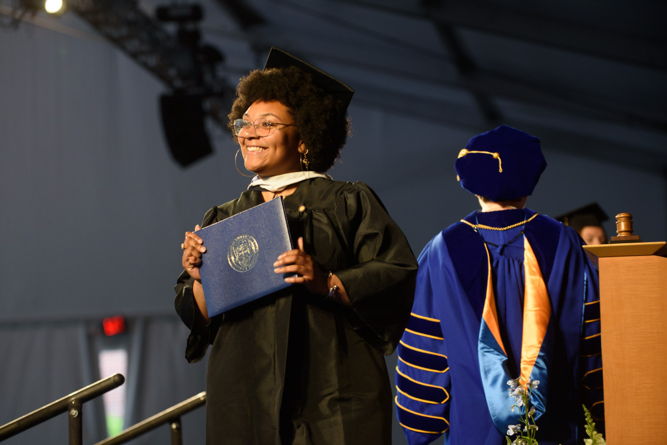student receives her diploma on stage
