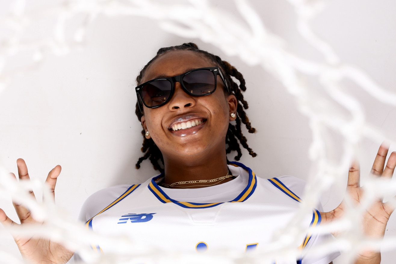 a woman wearing a white shirt under a basketball hoop 
