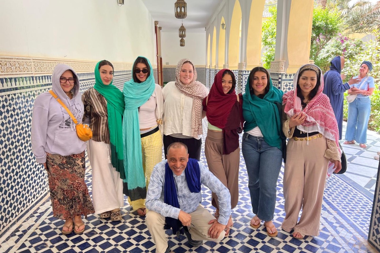 Students pose with a photo in Morocco with instructor Mustapha Sami