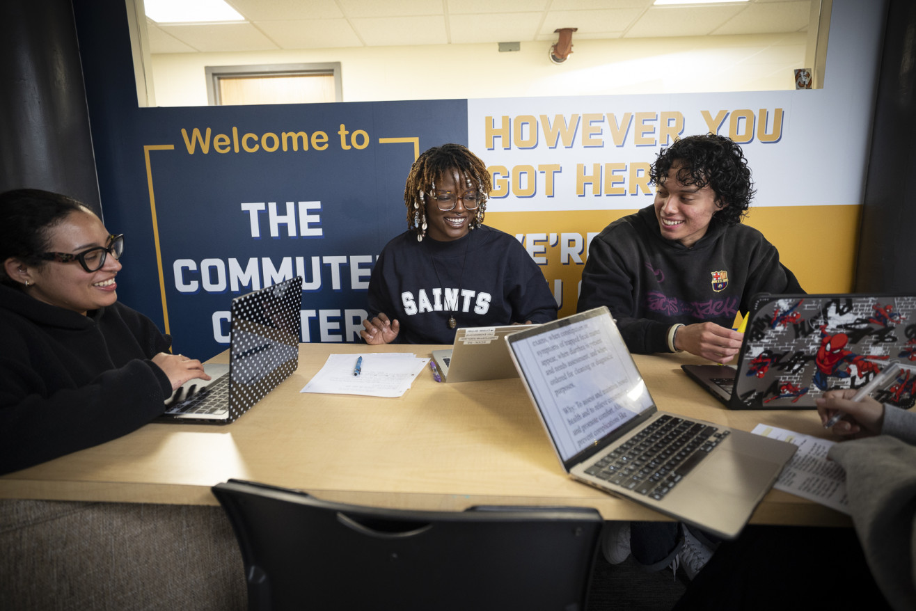 Students sit around a table studying in the Commuter Center