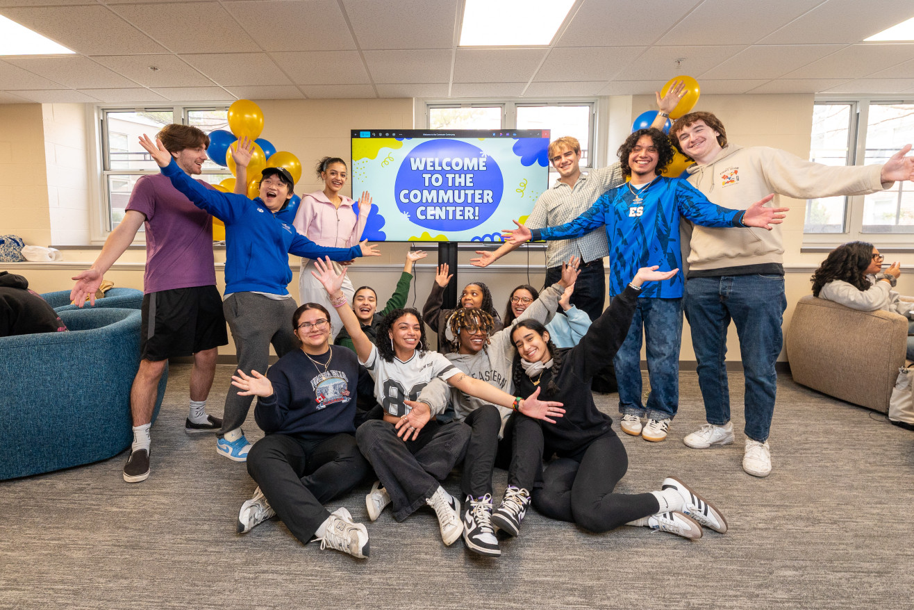 Students celebrate the new commuter center space in front of a screen that says "welcome"